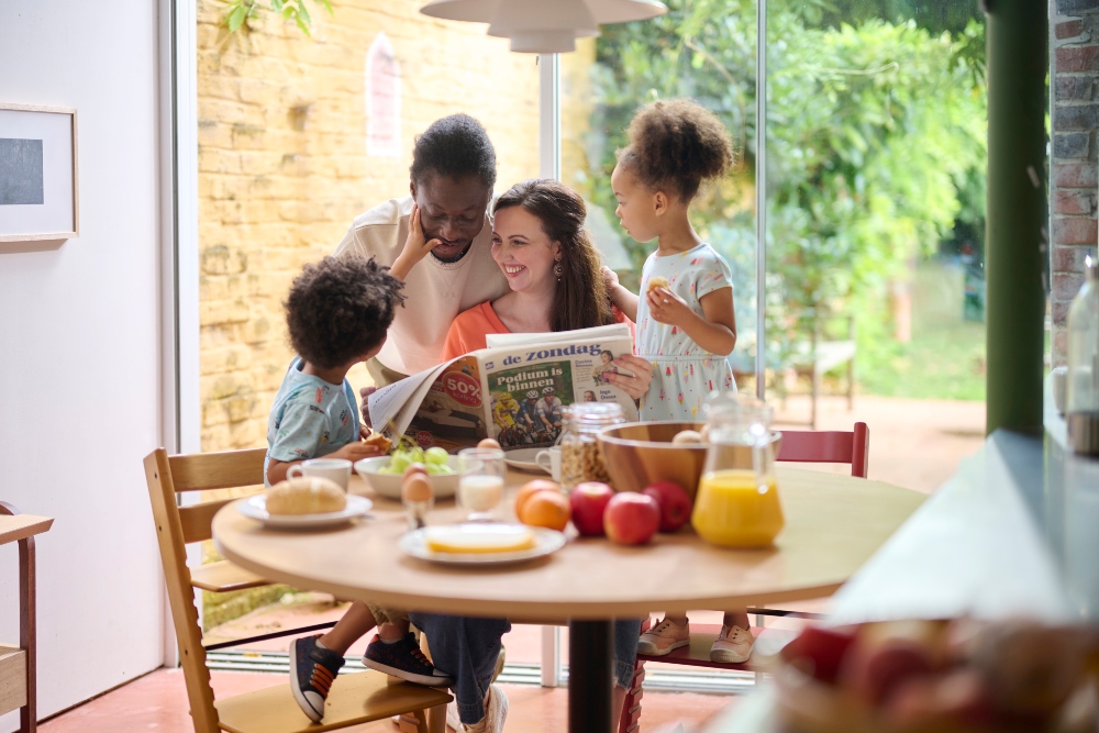 Gezin leest De Zondag aan ontbijttafel